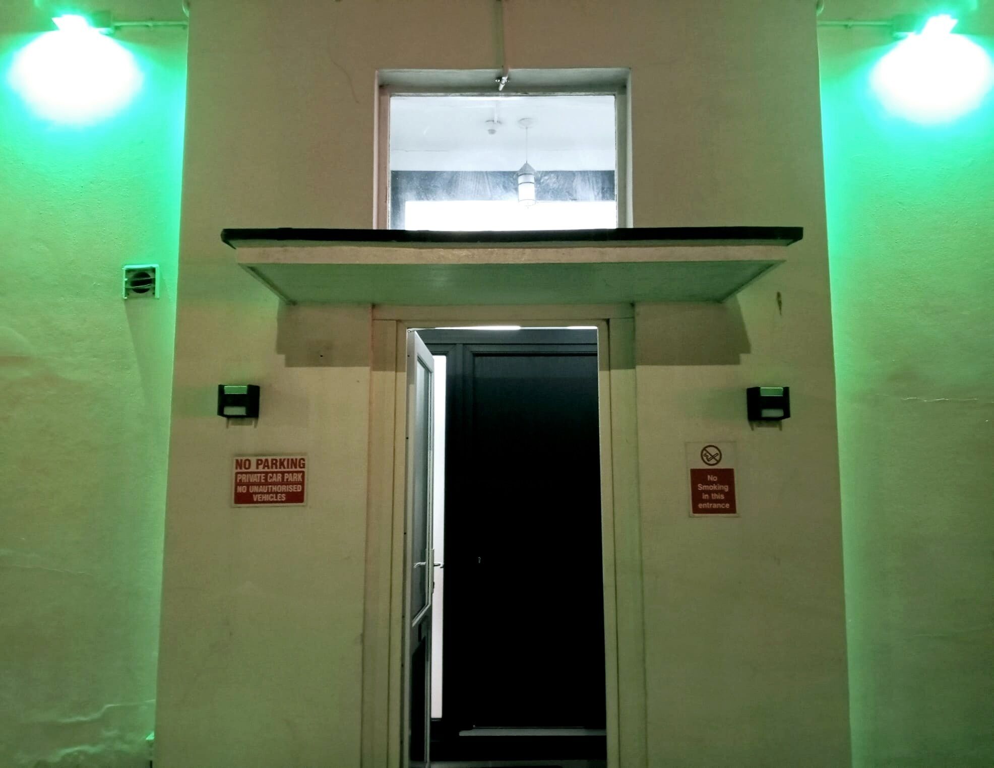 An elevator entrance with a 'No Smoking' sign and a 'No Parking' sign.