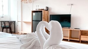 A hotel room with a bed, a desk, a television, and a refrigerator. - Sichon Residence (Sichon)