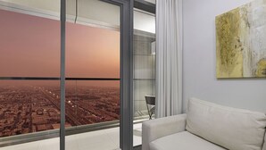 Ein modernes Wohnzimmer mit großem Fenster, einer Couch und einem Gemälde an der Wand.
