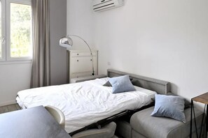 A bedroom with a bed, bedside table, lamp, and a window with curtains. - Boutique Apartment Florence “Diviso Due” (Florence)