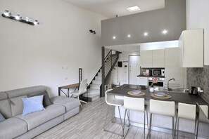 A modern apartment with a living area, kitchen, and dining space. - Boutique Apartment Florence “Diviso Due” (Florence)