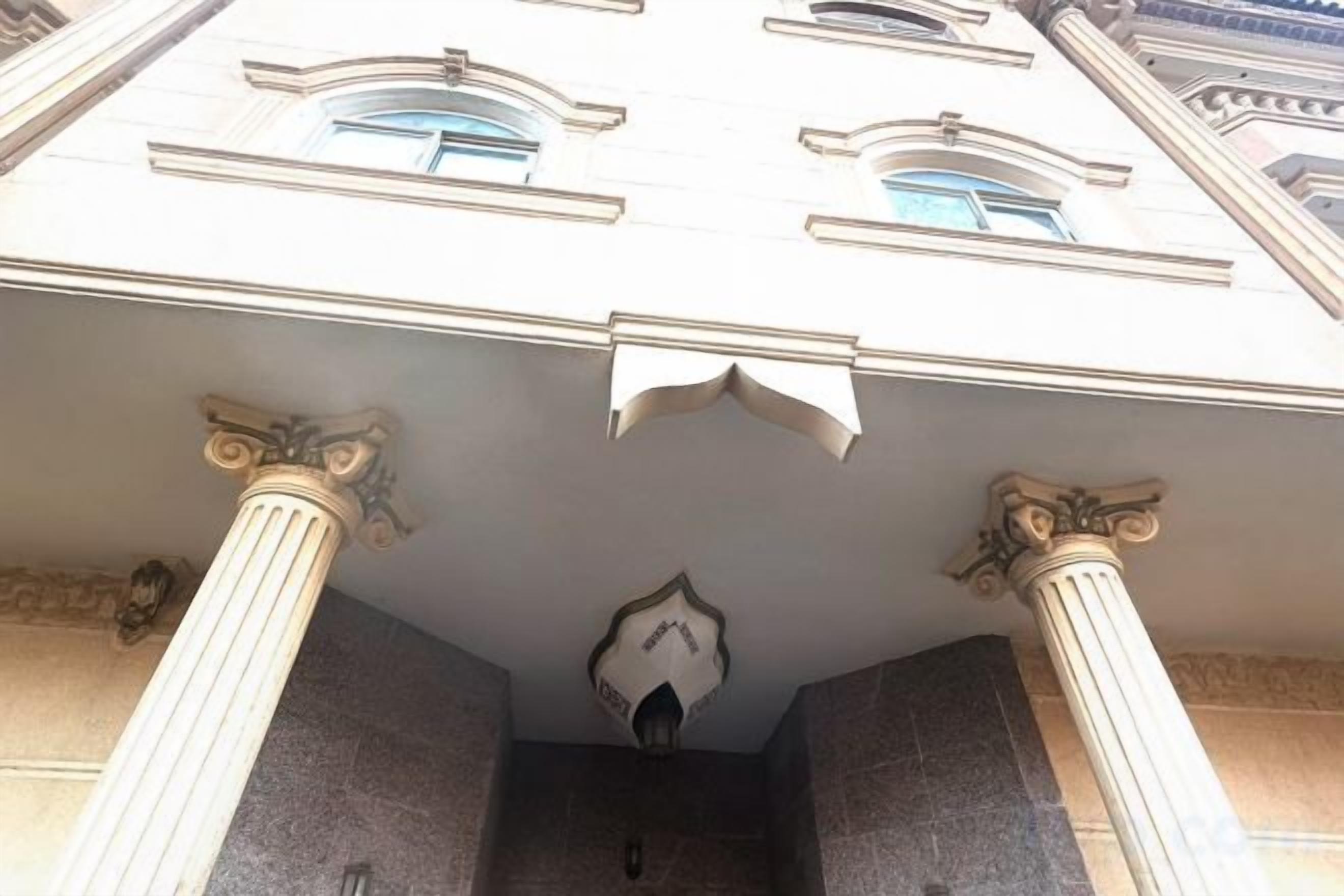 A building with classical architecture, featuring columns and a triangular pediment.