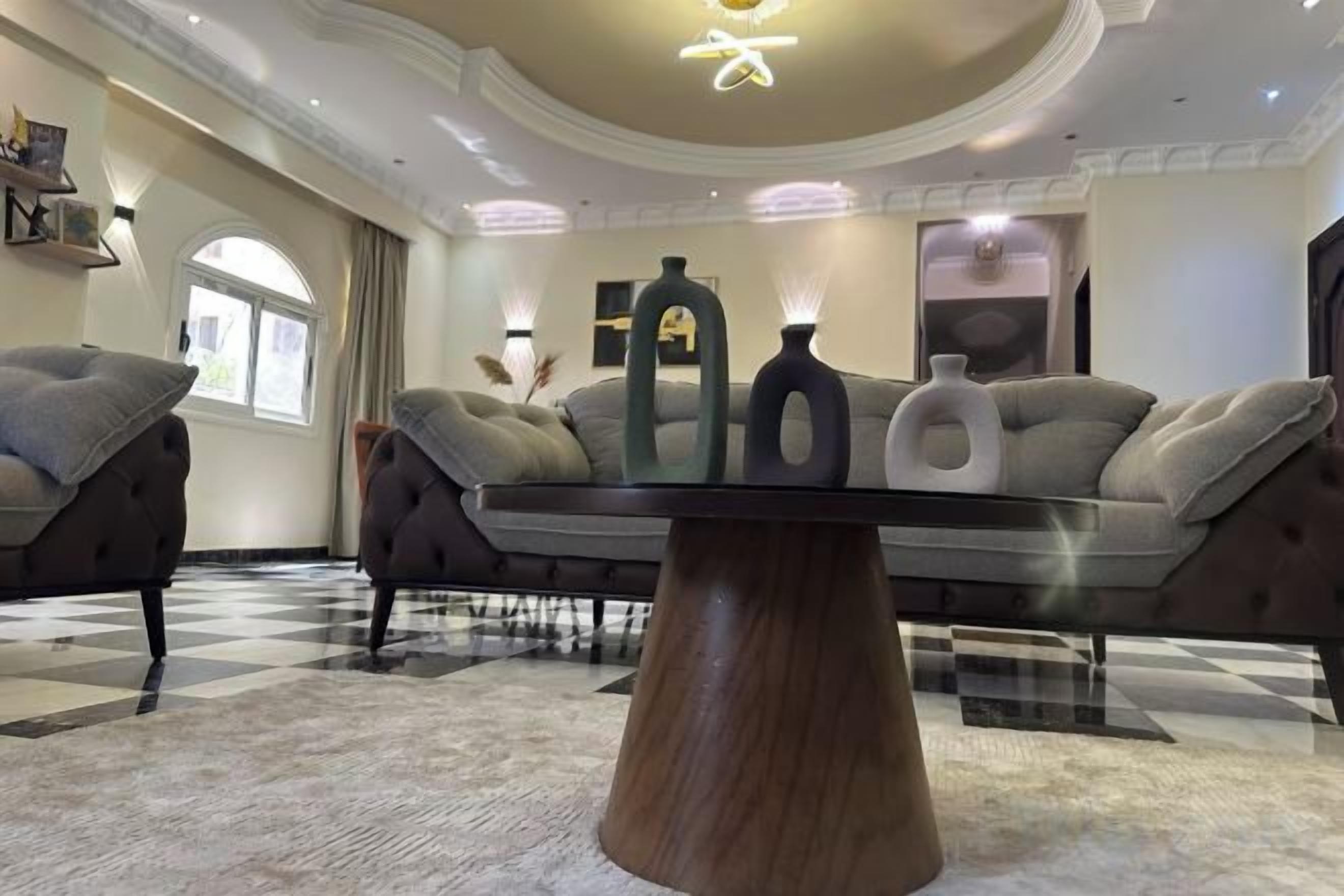 Una sala de estar moderna con sofá, una mesa de centro y jarrones decorativos.