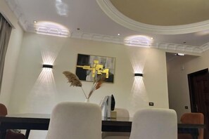 Un comedor con una mesa, sillas e iluminación en la pared.