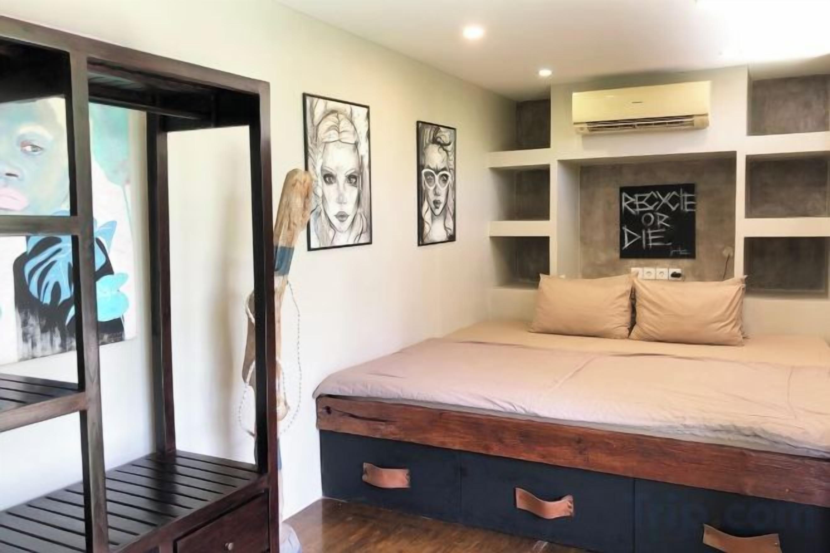 A bedroom with a bed, a wardrobe, and a wall-mounted shelf unit.