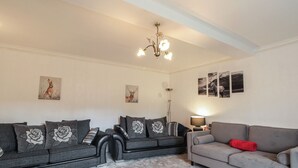 A living room with two sofas, a floor lamp, and wall art.