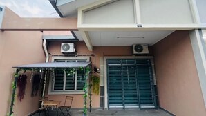 A residential building with a covered patio, air conditioning units, and a garage door. - Kulai 3B2R Indahpura Landed House Near JPO (Kulai)