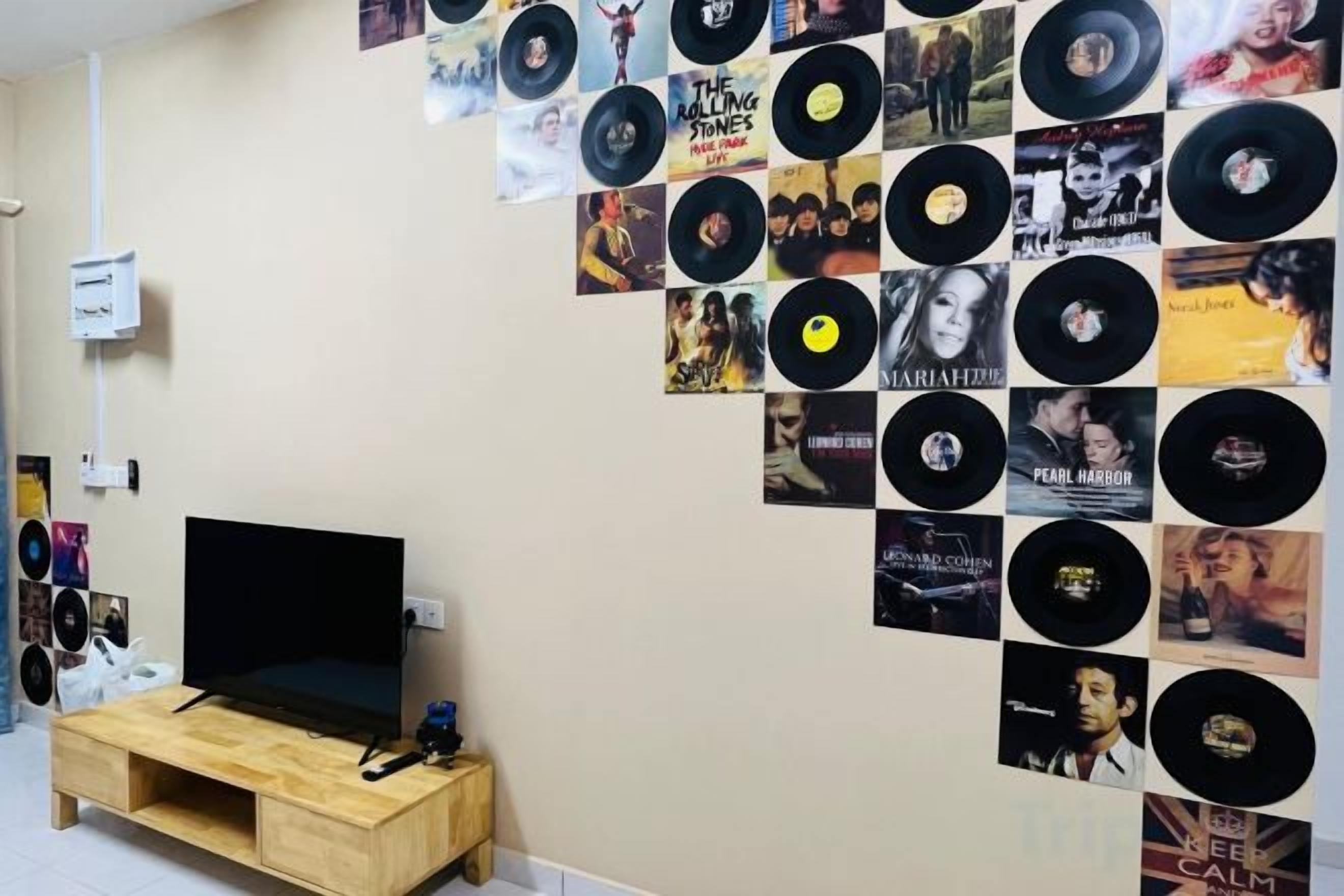 Een muur met een verzameling vinylplaten en albumhoezen.