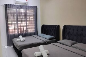 Habitación de hotel con dos camas, una ventana con cortinas traslúcidas y aire acondicionado instalado en la pared.