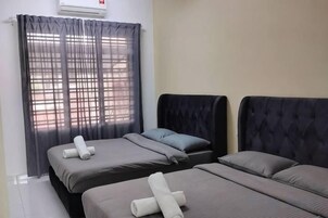 Habitación de hotel con dos camas, una ventana con cortinas y un aire acondicionado instalado en la pared.
