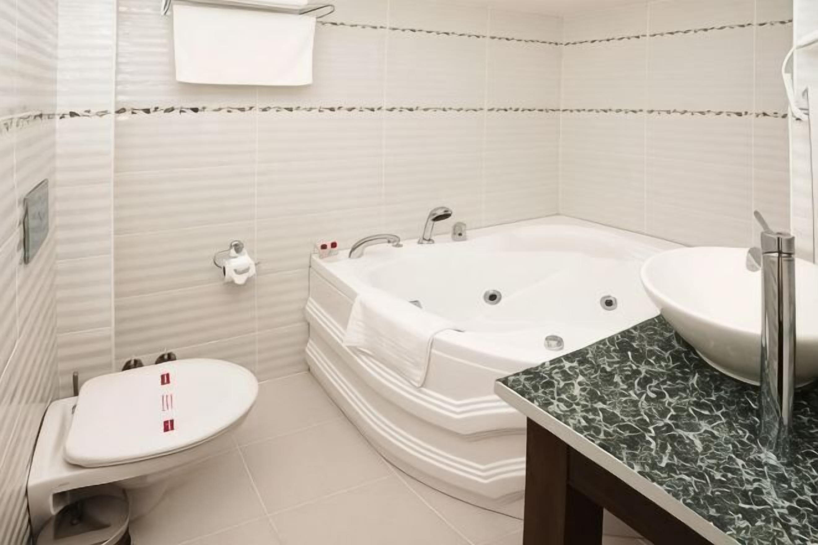 A bathroom with a toilet, a bathtub, and a sink.