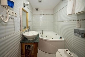 A bathroom with a sink, mirror, vanity, bathtub, toilet, and towel rack. - Fuat Bey Palace Hotel & Suites (Istanbul)
