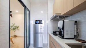 A modern kitchen with a stainless steel refrigerator, a coffee machine, and a sink. - Aradia by FEEL HOME (Kuala Lumpur)
