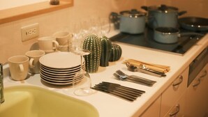 Un comptoir de cuisine avec divers ustensiles, assiettes et verres, ce qui indique la présence d’un coin repas.