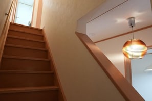 A wooden staircase with a modern light fixture above it. - Kyoto Guesthouse（Gojo） (Kyoto)