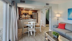 A modern apartment with a dining area, kitchen, and living room.