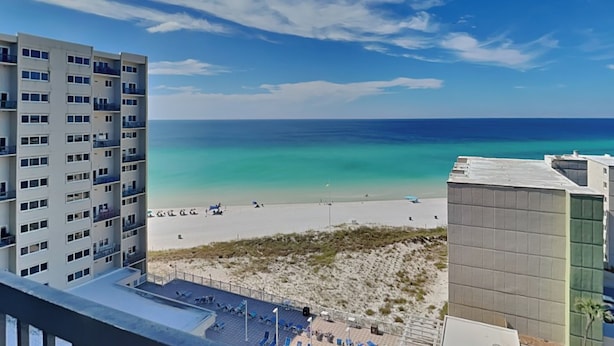 A high-rise building with a view of a beach and ocean.