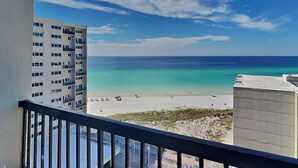 A high-rise building with a balcony overlooking a beach and ocean.