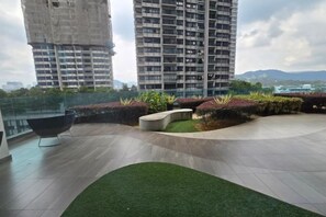 A rooftop terrace with a seating area, a small garden, and a view of surrounding buildings. - ARTE@AMPANG (Ampang)