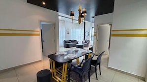 A modern dining area with a black table, gold accents, and black chairs. - ARTE@AMPANG (Ampang)