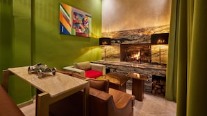 A modern lounge area with a fireplace, green walls, and a colorful abstract painting. - ZEN ZONE BOUTIQUE RIAD (Marrakech)