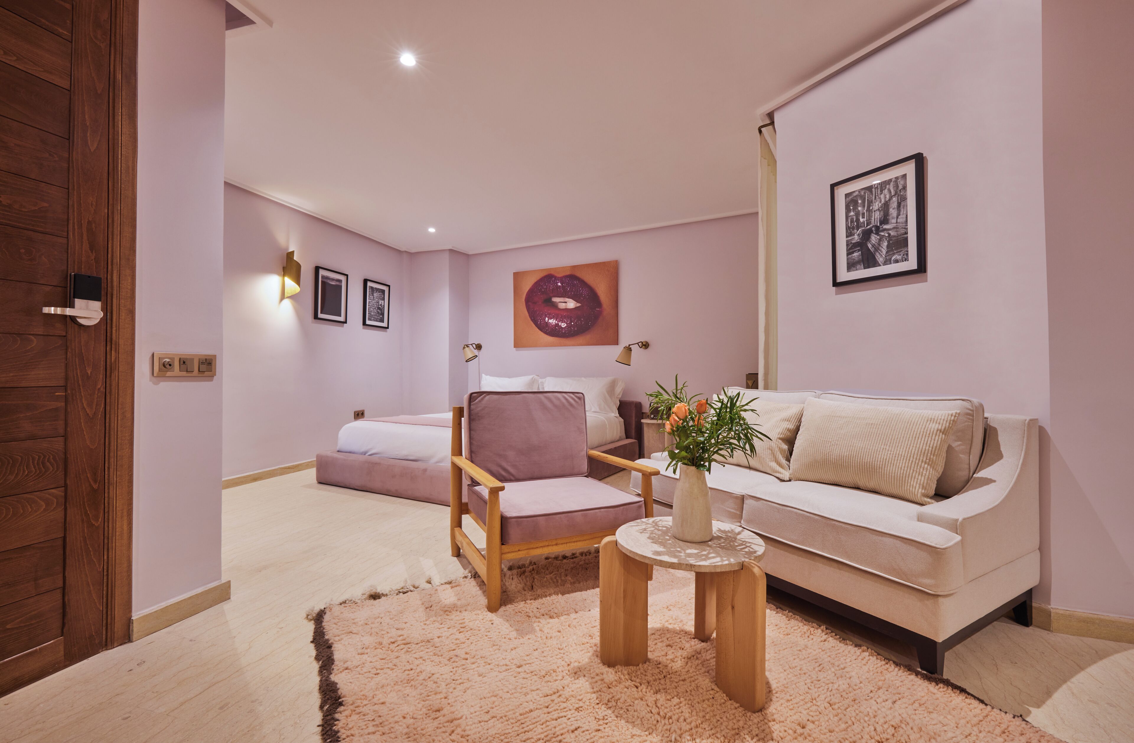 A modern living room with a sofa, armchair, and a small table with a vase.