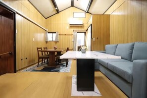 A compact room with a dining table, a sofa, and a small kitchen area. - Ideal momodani (Osaka)