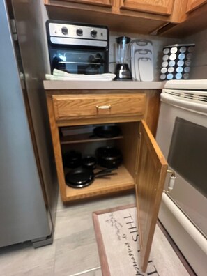 A compact kitchen with a built-in oven, a stovetop, and a wooden cabinet with a drawer. - Spacious Dunnellon House 3BR/2B  |7 Beds| Near Rainbow River (Dunnellon)