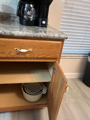 A kitchen with a granite countertop, a wooden drawer with a white handle, and a cabinet with a white bowl. - Spacious Dunnellon House 3BR/2B  |7 Beds| Near Rainbow River (Dunnellon)