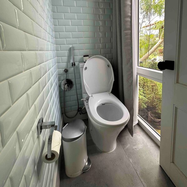 A bathroom with a toilet, bidet, and a trash can. - Venao - Blue27 Cozy Villa (Las Escobas del Venado)