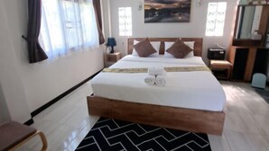 A hotel room with a bed, a nightstand, a desk, and a chair. - GuddahHomestay (Sawang Daen Din)