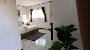 Un dormitorio moderno con cama, mesita de noche y un ventanal con cortinas.