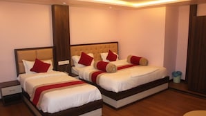 A hotel room with two beds, each with a wooden headboard, white bedding, and red pillows. - Hotel white palace airport Kathmandu  (Kathmandu)