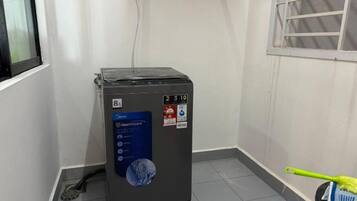 A compact, grey portable heater with a digital display and a blue label indicating it is a 'HeatPump' model.