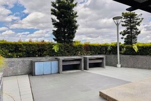 An outdoor seating area with a stone bench and a lamp post.