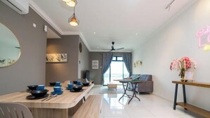 Una sala de estar moderna con comedor, ventilador de techo y un letrero de neón.