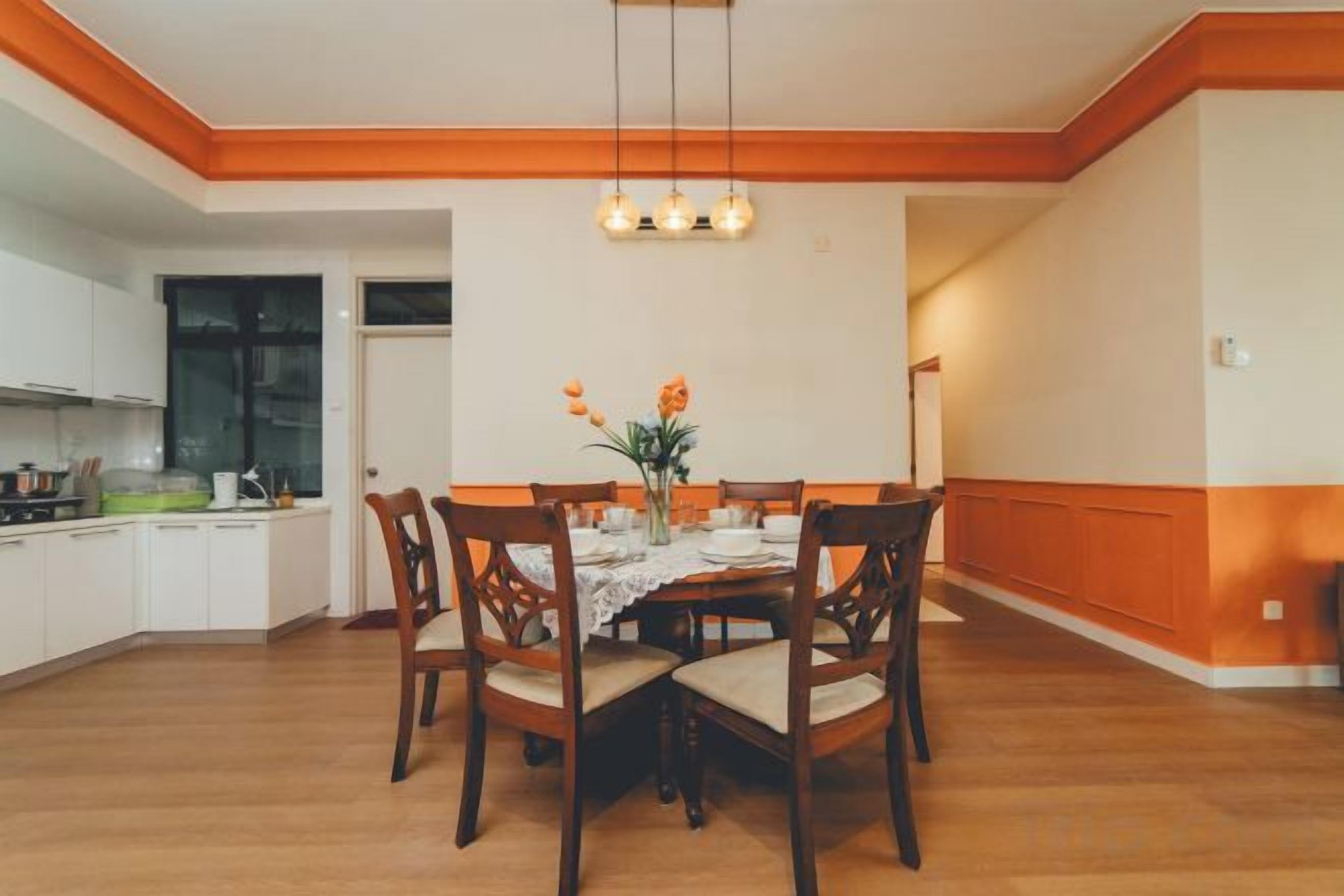 Un comedor con una mesa de madera, sillas y una lámpara colgante.