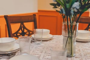 A dining table set with plates, bowls, and a glass.