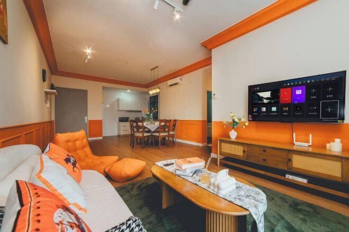 A modern living room with a sofa, a coffee table, and a TV mounted on the wall.