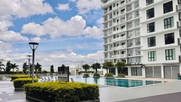 A modern building with a swimming pool, surrounded by well-maintained hedges and a clear sky. - The Platino Johor Bahru (Tebrau)