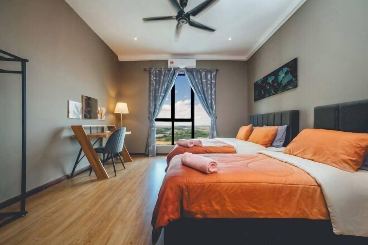 A bedroom with a bed, a desk, a chair, a ceiling fan, and a window with curtains.