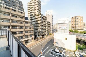 Un immeuble à plusieurs étages doté d’une architecture moderne, comprenant un mélange d’espaces résidentiels et commerciaux.