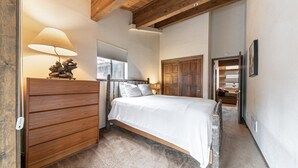 A bedroom with a wooden bed, a dresser, a lamp, and a window. - 254 Bldg D 2 Bedroom Townhouse (Truckee)
