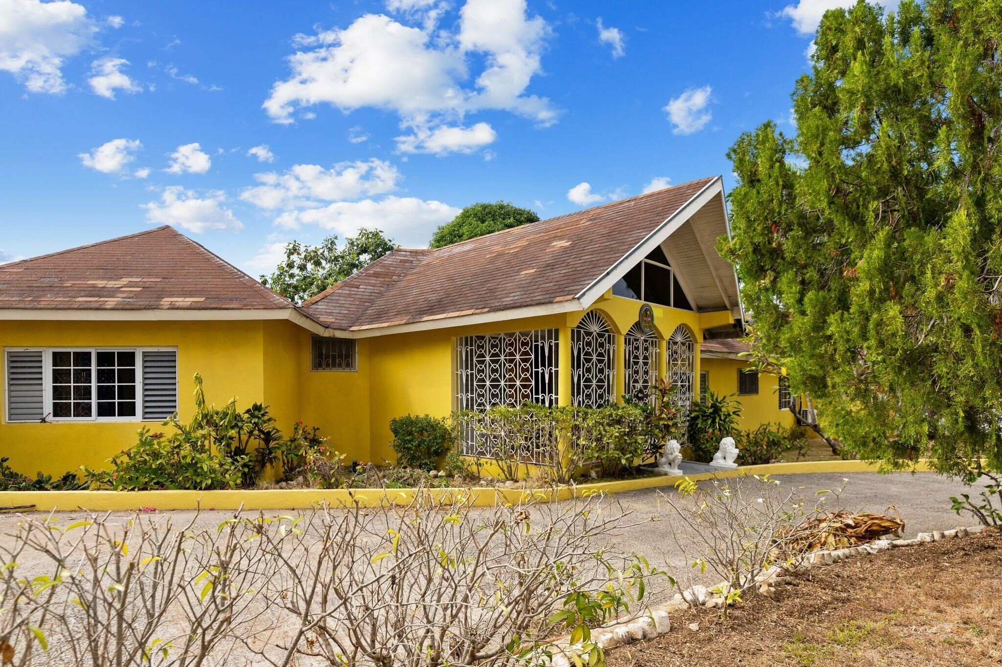 A yellow building with a sloped roof and a small porch.