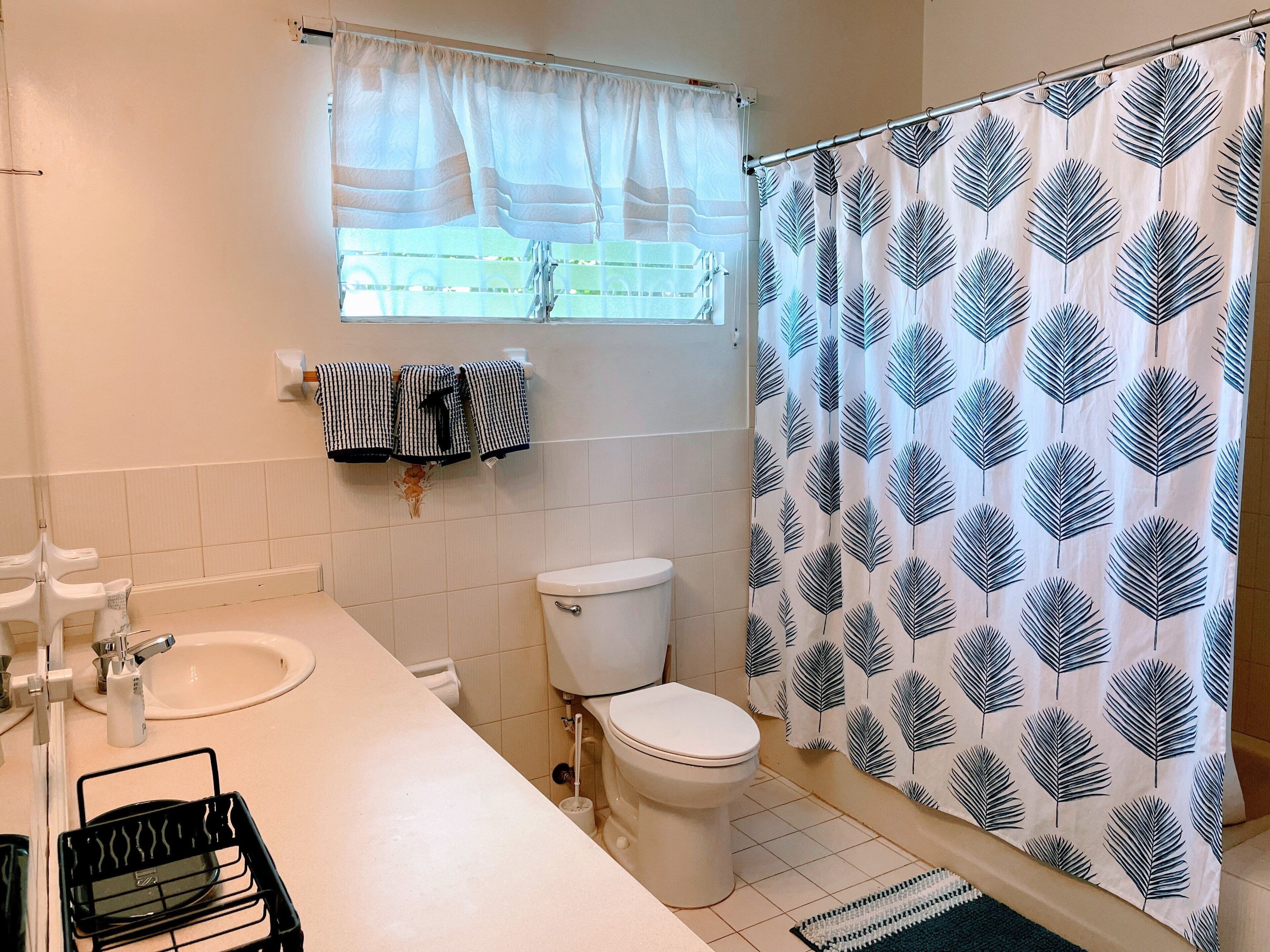 Ein Badezimmer mit Toilette, Waschbecken und Duschvorhang.