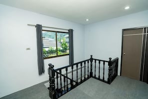 Una habitación con ventana, puerta y escalera.