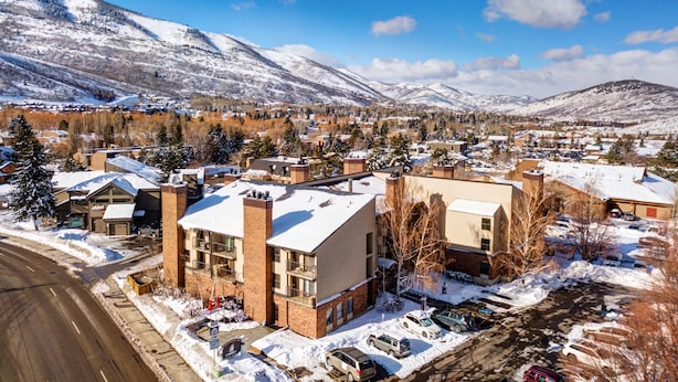 A town with snow-covered buildings and mountains in the background. - Copperbottom Inn 101 1 Bedroom Condo (Park City)