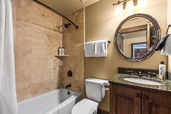 Une salle de bain avec une baignoire, des toilettes, un lavabo et un miroir.