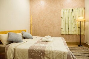 A neatly made bed with pillows, a bedside lamp, and a window with curtains. - Voon Cottages@Pinjistation Private Pool 10pax (Ipoh)