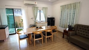 A living room with a dining table, chairs, a sofa, and a TV. - Voon Cottages@Pinjistation Private Pool 10pax (Ipoh)
